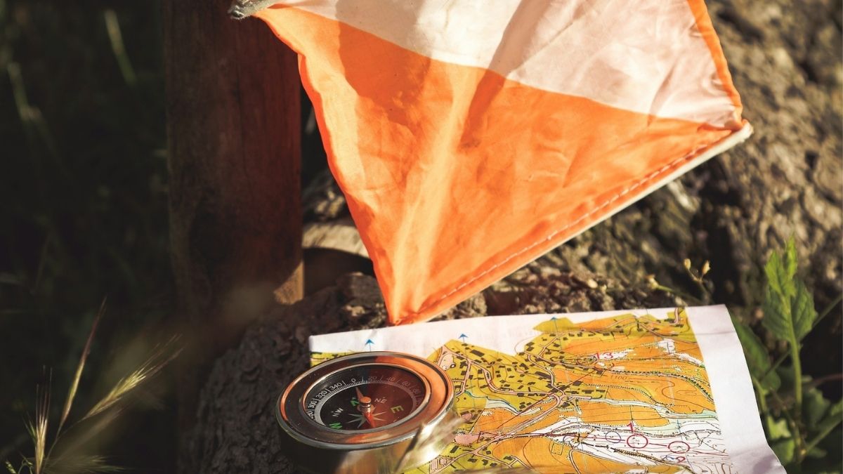 photo of a kite, compass, and map